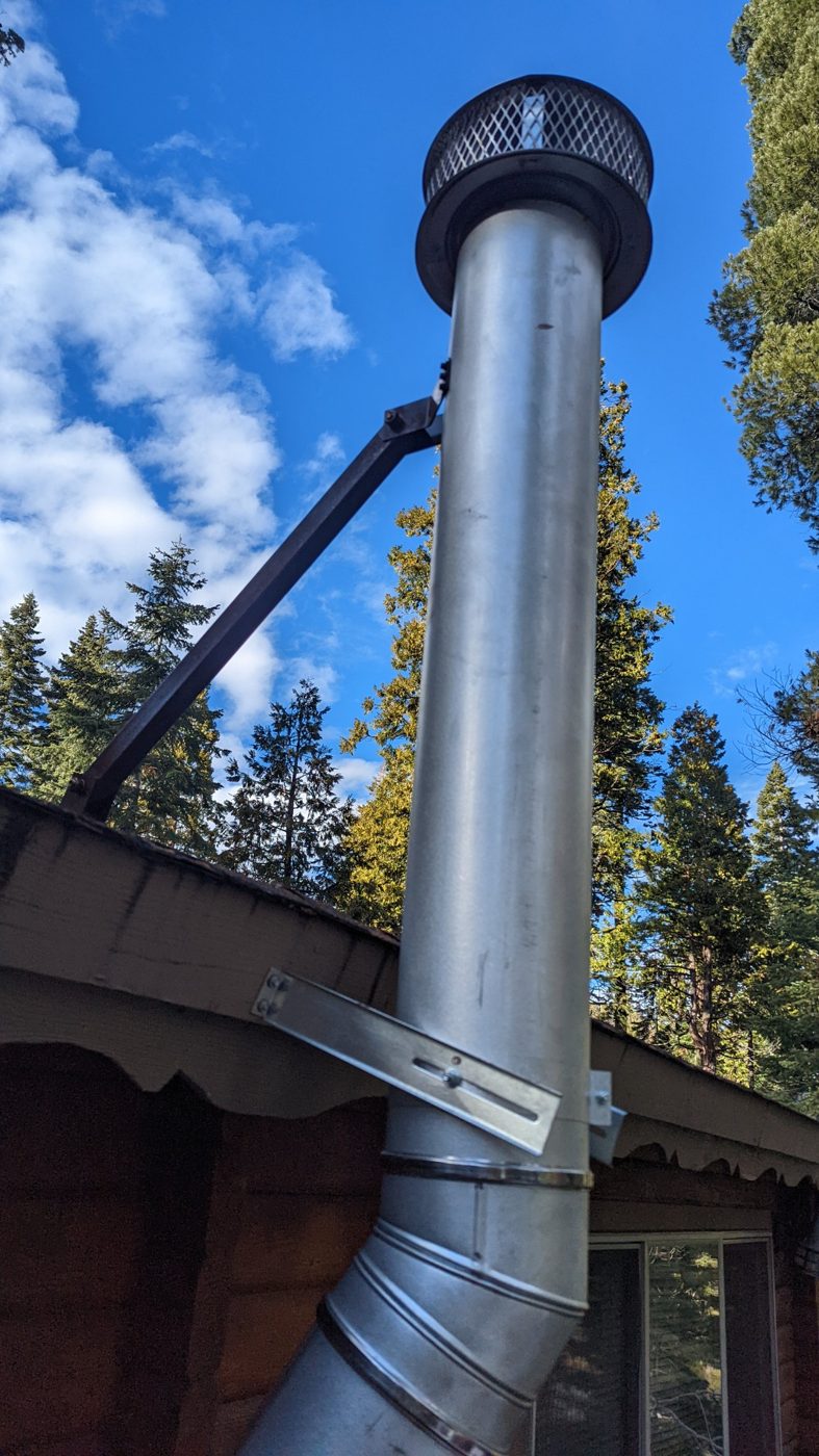 Galvanized chimney pipe with a painted spur brace and roof bracket